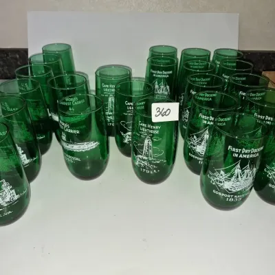 Sale Photo Thumbnail #623: Collection of green glass souvenir tumblers featuring white printed illustrations of Virginia naval landmarks and historical sites.