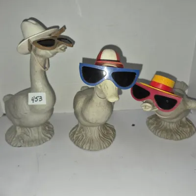 Sale Photo Thumbnail #784: Set of three vintage novelty duck figurines wearing colorful sunglasses and hats.