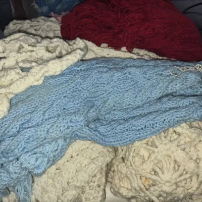 Sale Photo Thumbnail #74: Collection of handmade vintage knit and crochet blankets, including light blue, cream, and deep red yarn afghans.