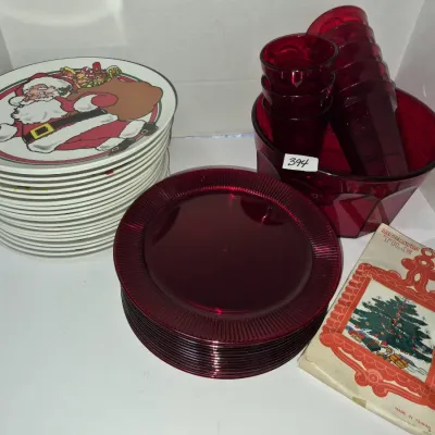 Sale Photo Thumbnail #688: Holiday tabletop collection including a stack of ceramic Santa Claus plates, ruby red glass plates, matching tumblers, a serving bowl, and a boxed vintage decorated tile trivet.