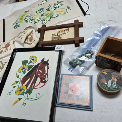 Sale Photo Thumbnail #200: Collection of vintage needlepoint artwork and decor items, including a framed embroidered horse motif, small rustic wooden frames, floral wall scroll, and duck-themed wooden boxes.