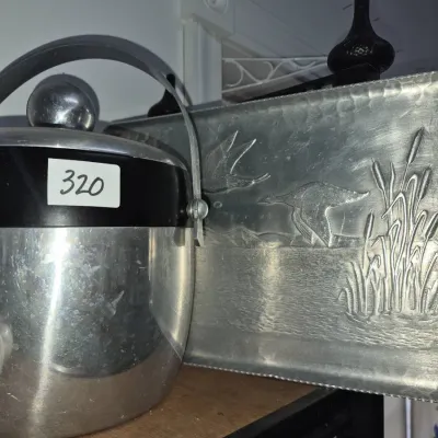 Sale Photo Thumbnail #558: Vintage West Bend aluminum ice bucket paired with a hammered aluminum tray featuring an embossed waterfowl and cattail scene.
