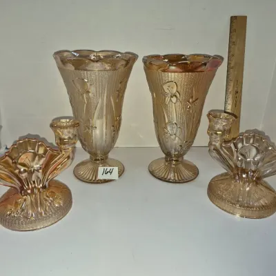 Sale Photo Thumbnail #285: Four-piece Jeanette Glass iridescent marigold Carnival glass set featuring two Iris and Herringbone pattern vases and a pair of double candleholders, circa 1920s-1930s.