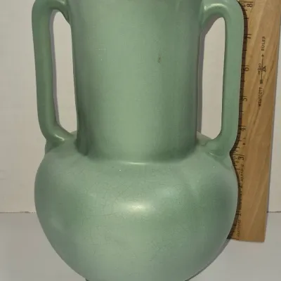 Sale Photo Thumbnail #260: Vintage double-handled pottery vase in a matte seafoam green glaze, measuring approximately 9 inches tall.