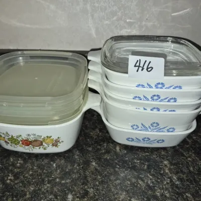 Sale Photo Thumbnail #731: Collection of vintage CorningWare grab-it and casserole dishes, featuring Cornflower Blue and Spice O' Life patterns with original glass and plastic lids.