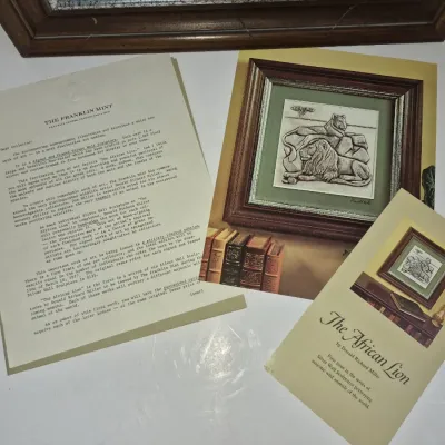 Sale Photo Thumbnail #595: The Franklin Mint promotional documentation and booklet for Donald Richard Miller's "The African Lion" silver wall sculpture, dated 1977.
