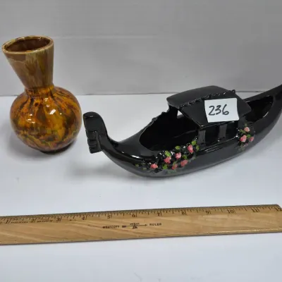 Sale Photo Thumbnail #404: Mid-century ceramic decor lot including a black gondola-shaped planter with hand-painted floral accents and a vintage drip-glaze pottery vase.