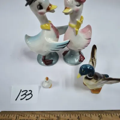Sale Photo Thumbnail #218: Collection of vintage ceramic duck figurines, featuring a anthropomorphic duck couple salt and pepper shaker set, a miniature mallard in flight, and a tiny duckling.