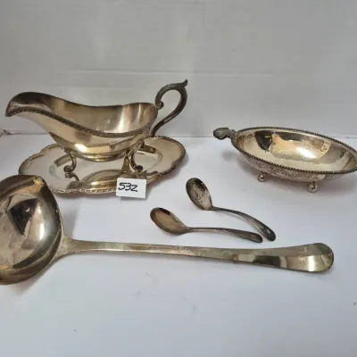Sale Photo Thumbnail #919: Vintage silver-plated hollowware selection including a gravy boat with attached underplate, a footed oval dish, a large ladle, and two small demitasse spoons.