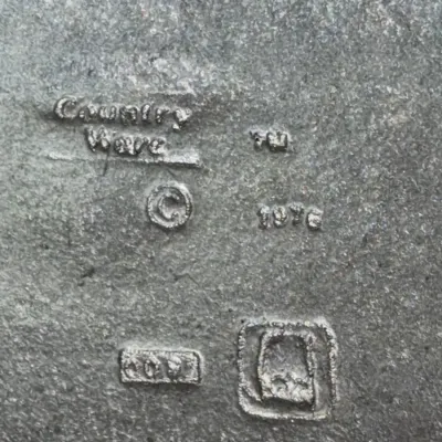 Sale Photo Thumbnail #643: Maker's mark closeup on a Country Ware metal item, stamped with a copyright date of 1976.
