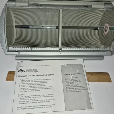 Sale Photo Thumbnail #778: Discgear 100-capacity CD/DVD media storage carousel with hinged cover, accompanied by Discware Lite installation instructions.