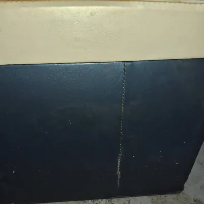 Sale Photo Thumbnail #11: Vintage two-tone vinyl storage ottoman or cooler box featuring a cream-colored lid and dark blue body with stitched vertical seams.