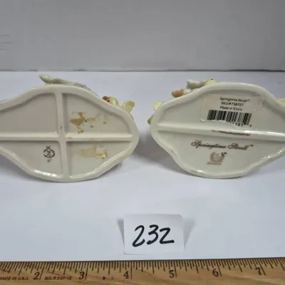 Sale Photo Thumbnail #399: Underside of a pair of Lenox porcelain figurines titled 'Springtime Stroll', showing maker marks and barcode labels.