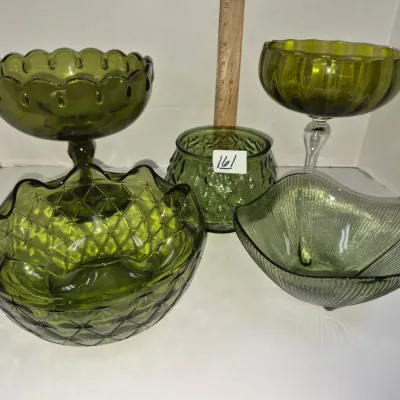 Sale Photo Thumbnail #281: Collection of mid-century avocado green glass glassware, including pedestal compotes, a ruffled diamond-pattern bowl, a ribbed dish, and a small planter.