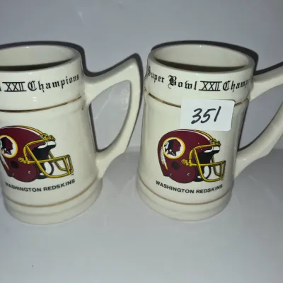 Sale Photo Thumbnail #613: Pair of vintage ceramic Washington Redskins Super Bowl XXII Champions commemorative steins with gold trim, circa 1988.