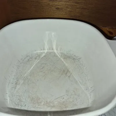 Sale Photo Thumbnail #699: Vintage white CorningWare square casserole dish showing heavy interior utensil wear and silver scratch marks.