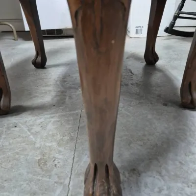 Sale Photo Thumbnail #196: Close-up of a carved cabriole leg with a ball-and-claw foot on a traditional wooden table or chair.