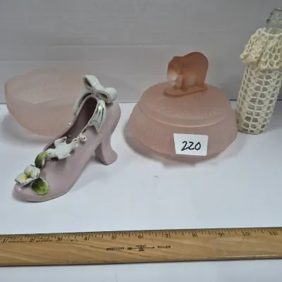 Sale Photo Thumbnail #378: Collection of vintage decorative glass and ceramic items, including a pink frosted satin glass elephant trinket box, a ceramic high heel shoe figurine with applied flowers, and a glass bottle with a crocheted cover.