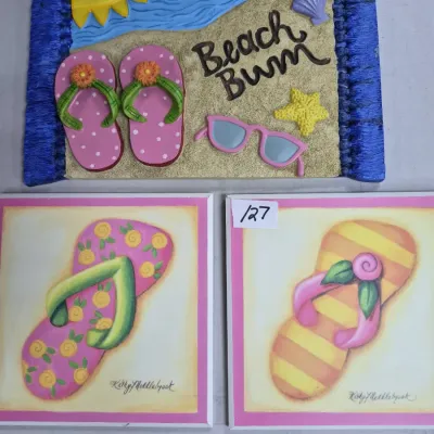 Sale Photo Thumbnail #208: Set of beach-themed wall decor, including a 3D resin 'Beach Bum' plaque and two framed floral flip-flop artwork prints by Kathy Middlebrook.