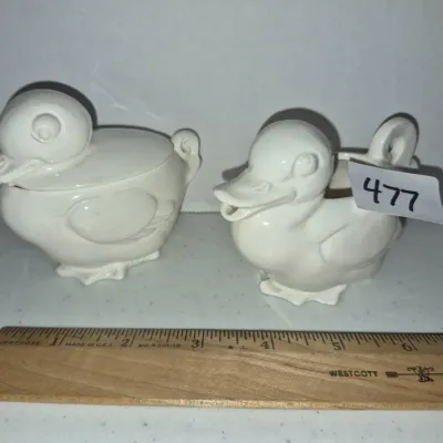 Sale Photo Thumbnail #820: Pair of vintage white ceramic duck-shaped creamer and sugar bowl set, with a wooden ruler shown for scale.