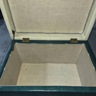 Sale Photo Thumbnail #6: Vintage mid-century storage bench ottoman, featuring a dark green vinyl exterior, a cream-colored hinged lid, and a fabric-lined interior storage compartment.