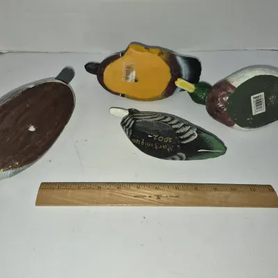 Sale Photo Thumbnail #793: Set of four small decorative duck figurines shown from the underside, alongside a 12-inch wooden Westcott ruler for scale.