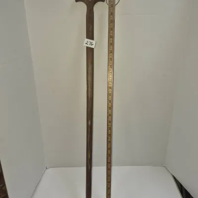 Sale Photo Thumbnail #467: Vintage dark wood walking cane with a T-handle and metal tip, measuring approximately 35 inches long.