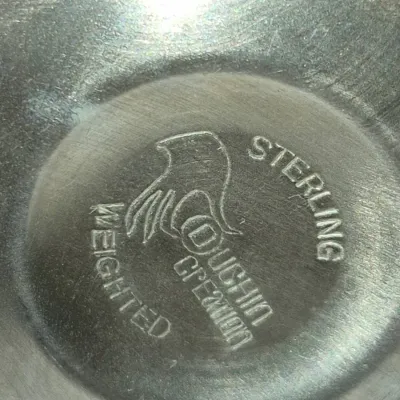 Sale Photo Thumbnail #909: Close-up view of a Duchin Creation maker's mark stamped on a weighted sterling silver item.