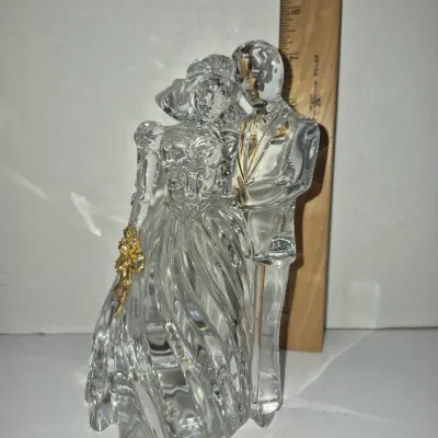 Sale Photo Thumbnail #349: Clear crystal bride and groom figurine with gold-tone accents, standing alongside a wooden ruler for scale measurement.