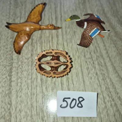 Sale Photo Thumbnail #875: Set of three vintage novelty brooches, including a carved wooden flying bird, a painted mallard duck, and a carved black walnut slice pin.