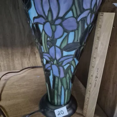 Sale Photo Thumbnail #33: Tiffany-style stained glass trumpet vase table lamp featuring purple floral panels on a dark metal base, measuring approximately 12 inches tall.