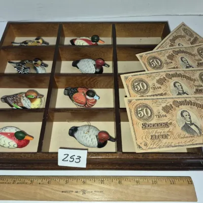 Sale Photo Thumbnail #431: Wooden shadow box display tray containing miniature duck figurines, alongside several replica Confederate $50 bills.