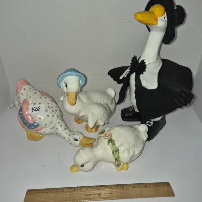 Sale Photo Thumbnail #746: Collection of four vintage ceramic and fabric-dressed duck figurines in various poses.