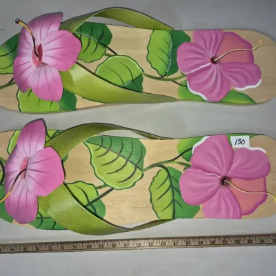 Sale Photo Thumbnail #212: Pair of large decorative wooden flip-flop wall hangings featuring hand-painted pink hibiscus flowers and green leaves.