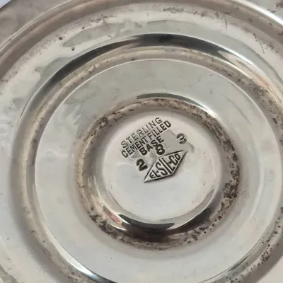 Sale Photo Thumbnail #896: Bottom detail of an El-Sil-Co sterling silver weighted base item, stamped with manufacturer hallmarks and model numbers.