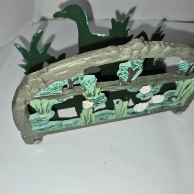 Sale Photo Thumbnail #701: Vintage painted cast metal napkin holder featuring a pond scene with a swan, water lilies, and foliage.