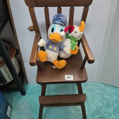 Sale Photo Thumbnail #808: Miniature wooden high chair for dolls featuring a Donald Duck plush and a goose plush doll.