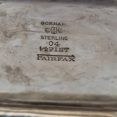 Sale Photo Thumbnail #891: Gorham Sterling Fairfax pattern mark stamped on the underside of a half-pint silver item, showing maker's hallmarks and model number 04.