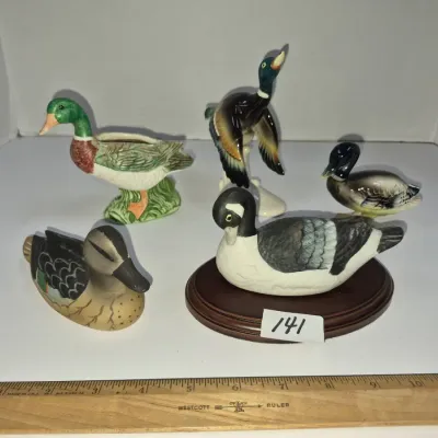 Sale Photo Thumbnail #237: Collection of five vintage ceramic duck figurines in various poses and finishes, including one mounted on a wooden display base.