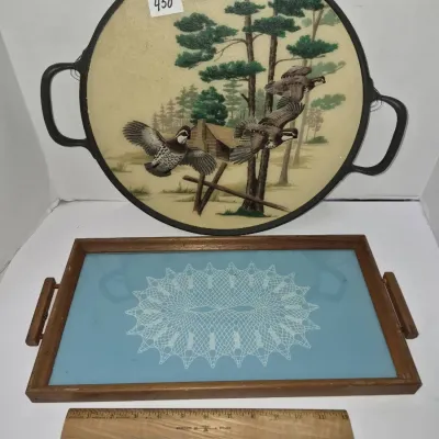 Sale Photo Thumbnail #779: Two vintage serving trays, including a round tray with a wildlife scene depicting quails in flight and a rectangular wooden tray with a blue doily design under glass.