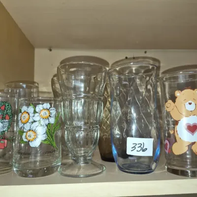 Sale Photo Thumbnail #584: Collection of vintage glass drinkware, including a Care Bears graphic glass, printed floral tumblers, and pressed soda fountain glassware.