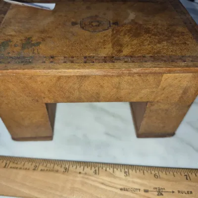 Sale Photo Thumbnail #142: Vintage inlaid wood miniature desk or stool trinket box with marquetry border and central inlay, showing light surface wear and staining.