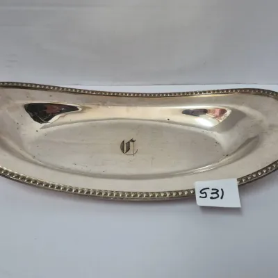 Sale Photo Thumbnail #917: Monogrammed silver-tone elongated dish featuring a beaded border rim and a single engraved letter monogram in the center.