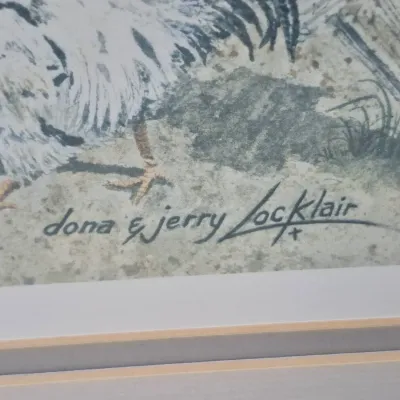 Sale Photo Thumbnail #486: Close-up of a signature reading "Dona & Jerry Locklair" on a matted artwork featuring a chicken.