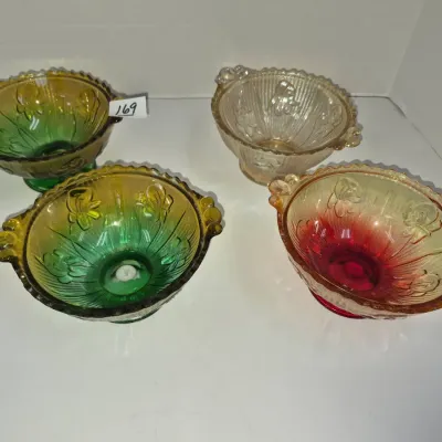 Sale Photo Thumbnail #291: Set of four vintage carnival and iridescent pressed glass dessert bowls featuring floral embossing and handles in varied colors including green, yellow, and red.