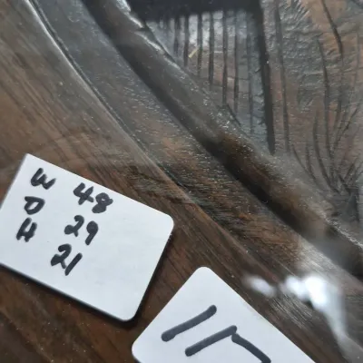 Sale Photo Thumbnail #195: Close-up of a carved dark wood tabletop under a glass surface, displaying handwritten dimension and item tag cards.
