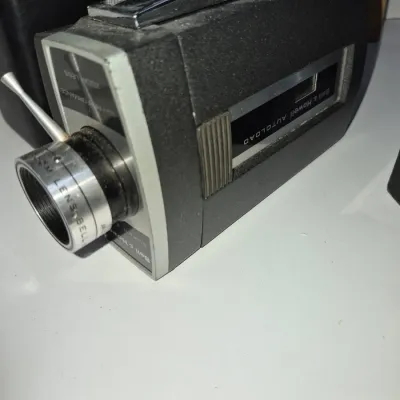 Sale Photo Thumbnail #310: Vintage Bell & Howell Autoload Super 8 movie camera with a metal top handle and adjustable zoom lens.