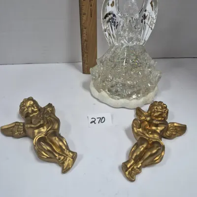 Sale Photo Thumbnail #459: Glittery acrylic illuminated angel figure paired with a set of two gold-painted plastic cherub wall plaques, measuring approximately 8 inches tall.