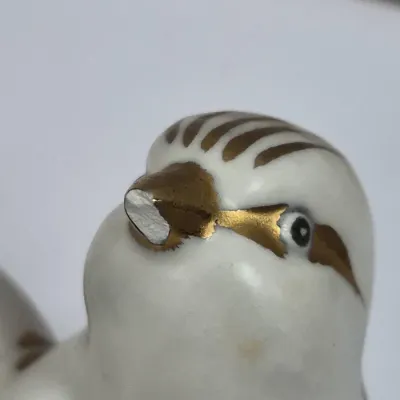 Sale Photo Thumbnail #381: Close-up of a porcelain bird figurine with gold trim, showing a chipped or broken beak.