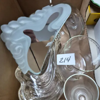 Sale Photo Thumbnail #366: Collection of decorative glassware and mirrors, including an Art Deco style frosted glass mirror frame, a clear textured glass tray, and stemware, packed in a cardboard box.